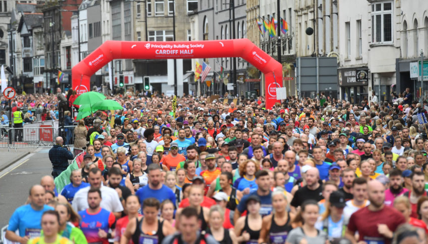 Large crowds of people running the Cardiff Half Marathon.