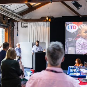 Seb Choudhury (ITV) speaking to a room full of people at Let's Talk Dementia 2024.